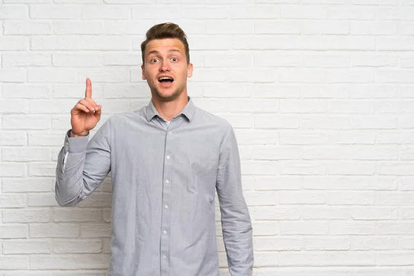 Blonde Man White Brick Wall Thinking Idea Pointing Finger — Stock Photo, Image