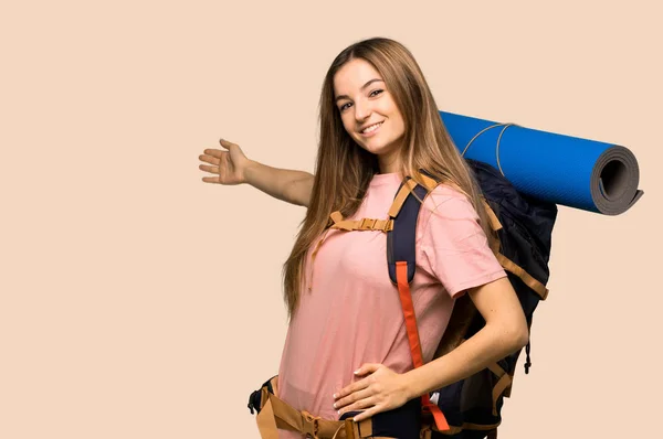 Νεαρή Γυναίκα Backpacker Δείχνοντας Προς Πίσω Και Παρουσιάζοντας Ένα Προϊόν — Φωτογραφία Αρχείου