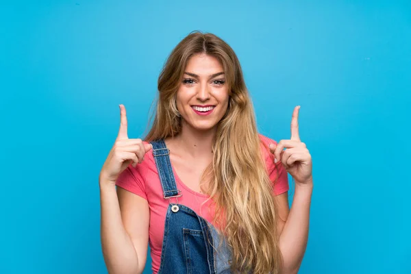 Giovane Donna Bionda Con Tuta Sopra Isolato Muro Blu Che — Foto Stock