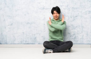 Asyalı adam hiçbir jest yaparak katta oturan