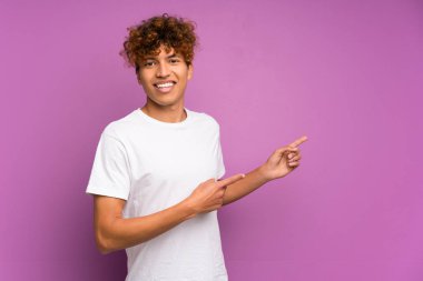 Izole mor duvar tarafında parmak işaret üzerinde genç afro-amerikan adam