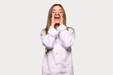 Genç doktor kadın bağırıyor ve gri arka planda bir şey duyuruyor.