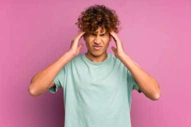 Genç Afro-Amerikalı bir adam, izole edilmiş mor bir duvarın üzerinde mutsuz ve hayal kırıklığına uğramış bir şekilde. Olumsuz yüz ifadesi