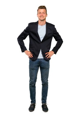 Sarışın yakışıklı adam kalça kolları ile poz ve gülümseyerek