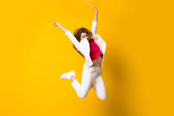 Mujer Joven Saltando Sobre Pared Amarilla Aislada —  Fotos de Stock