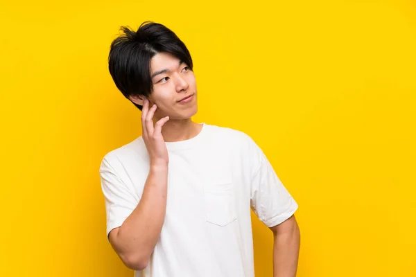 Asiático Hombre Sobre Aislado Amarillo Pared Pensamiento Idea —  Fotos de Stock