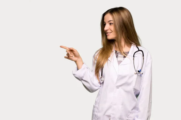 Νεαρή Γιατρός Γυναίκα Δείχνοντας Δάχτυλο Στο Πλάι Στην Πλευρική Θέση — Φωτογραφία Αρχείου