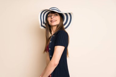 Arka planda bikinili bir kadın gülüyor.