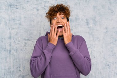 Sürpriz yüz ifadesi ile grunge duvar üzerinde genç afro-amerikan adam