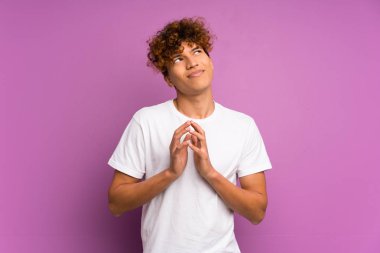 Genç Afrikalı Amerikalı bir adam, izole edilmiş mor duvar entrikaları çeviriyor.