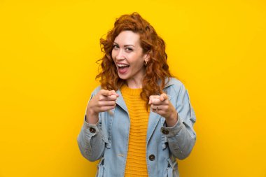 Izole sarı arka plan noktaları üzerinde Redhead kadın size parmak