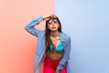 Bikinili genç bir kadın, bir şeye bakmak için çok uzaklara bakıyor.