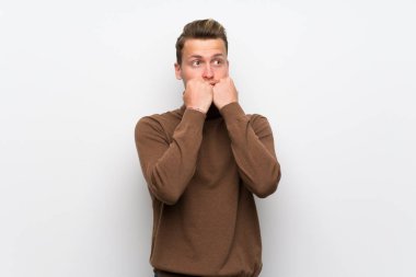 Izole beyaz duvar üzerinde Blonde adam biraz gergin ve ağızellerini koyarak korkuyor