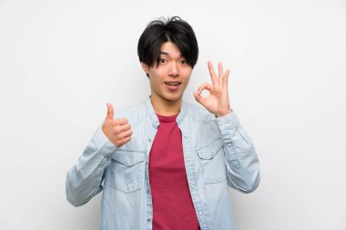 Izole beyaz arka plan üzerinde Asyalı adam ok işareti ve başparmak yukarı jest gösteren