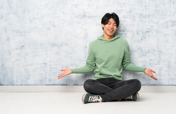 Asiatischer Mann Sitzt Lächelnd Auf Dem Boden — Stockfoto