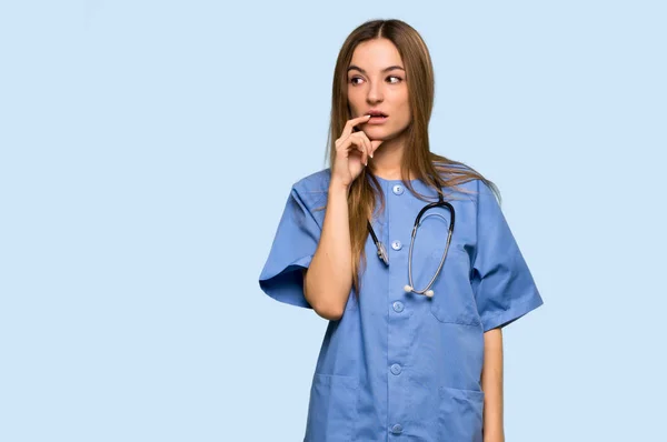 Young Nurse Having Doubts While Looking Isolated Blue Background — Stock Photo, Image