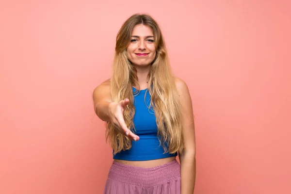 Mujer Rubia Joven Sobre Fondo Rosa Aislado Estrechando Las Manos —  Fotos de Stock