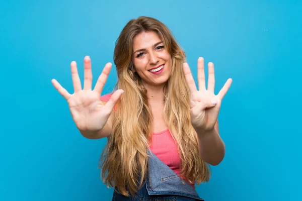 Genç Sarışın Kadın Mavi Duvardan Aşağı Yuvarlanmış Parmaklarıyla Dokuzu Sayıyor — Stok fotoğraf