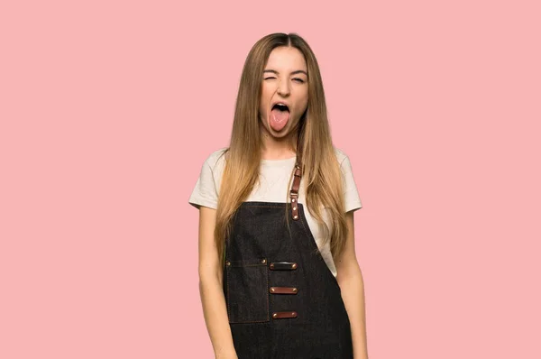 Ung Kvinna Med Förkläde Visar Tunga Vid Kameran Med Rolig — Stockfoto