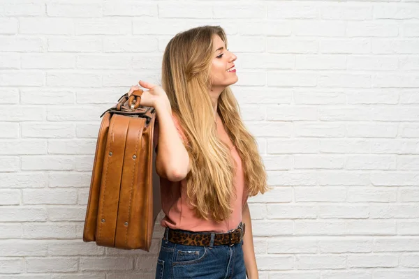 Joven Mujer Rubia Sobre Pared Ladrillo Blanco Sosteniendo Maletín Vintage —  Fotos de Stock