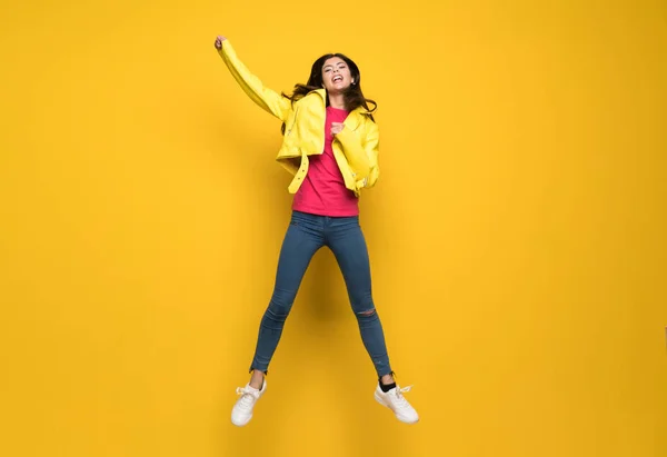 Dospívající dívka, která skočila přes izolované žluté zeď — Stock fotografie