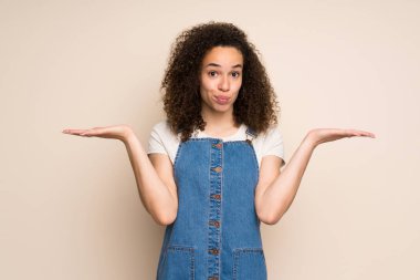 Elleri kaldırırken şüpheleri olan tulumlu Dominikli kadın