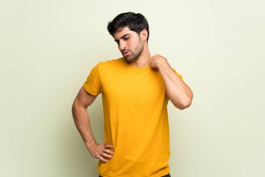 Genç adam yorgun ve hasta ifade ile pembe duvarın üzerinden