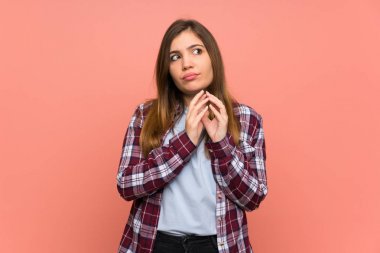 Young girl over pink wall scheming something