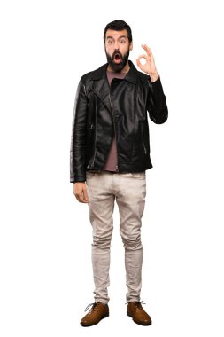 Sakal şaşırmış ve izole beyaz arka plan üzerinde gösteren ok işareti ile yakışıklı adam