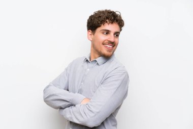 Sarışın adam gülüyor izole beyaz duvar üzerinde