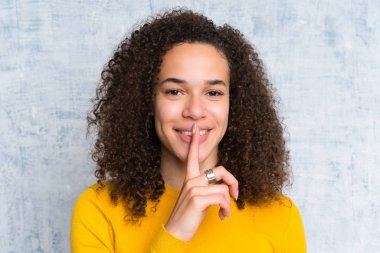 Izole yeşil arka plan üzerinde Dominikli kadın sessizlik jest yapıyor