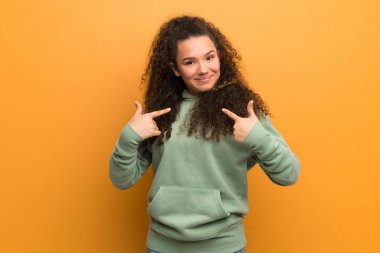 Genç kız sürpriz yüz ifadesi ile okra duvarın üzerinden