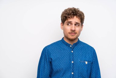 Mavi gömlek ayakta ve yan bakıyor sarışın adam