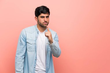 Pembe duvar öne dönük ve hayal kırıklığına uğramış genç adam