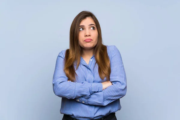 Young Girl Isolated Blue Wall Making Doubts Gesture While Lifting — 스톡 사진