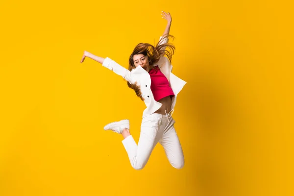 Mujer Joven Saltando Sobre Pared Amarilla Aislada —  Fotos de Stock