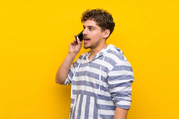 Blonder Mann Über Gelbe Wand Der Mit Dem Handy Telefoniert — Stockfoto