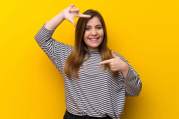 Chica Joven Sobre Pared Amarilla Enfocando Cara Símbolo Encuadre —  Fotos de Stock
