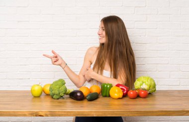Birçok sebze ile genç kadın yan parmak işaret