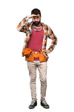 Esnaf adam izole beyaz arka plan üzerinde bir şey bakmak için el ile uzak bakıyor