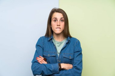 Renkli arka plan üzerinde genç kadın şüpheleri olan ve yüz ifadesi karıştırmayın