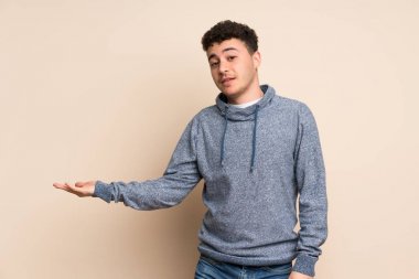 Genç adam izole duvar üzerinde bir fikir sunma sırasında gülümseyen bakarak