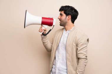 Genç adam bir megafon ile bağırarak izole duvarın üzerinden