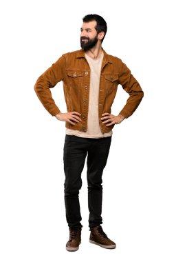 Silah, kalça ile poz ve izole beyaz arka plan üzerinde gülümseyen sakallı yakışıklı adam