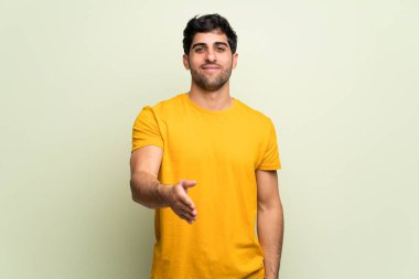 İyi bir anlaşma kapanış tokalaşırken pembe duvarın üzerinden genç adam