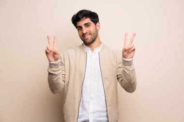 Her iki el ile zafer işaret gösteren izole duvarın üzerinden genç adam