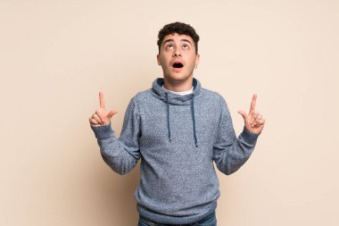 İzole edilmiş duvarın üzerindeki genç adam şaşırmış ve yukarı bakıyor.