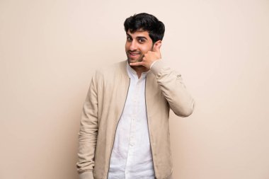 Yalıtılmış duvar telefon jest yapma genç adam. Bana arka işareti de