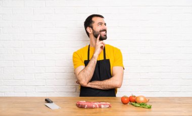 Şef bir mutfak tutarak bir fikir düşünürken yukarı bakıyor