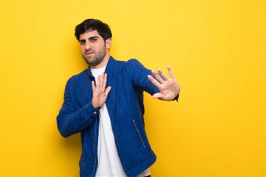 Sarı duvar üzerinde mavi ceketli adam sinir ön elleri germe